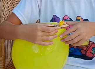 manos poniendo un broche a un globo inflado
