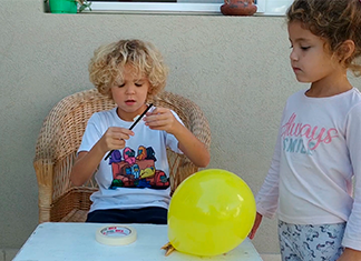 dos hermanitos preparando experimento acción y reacción