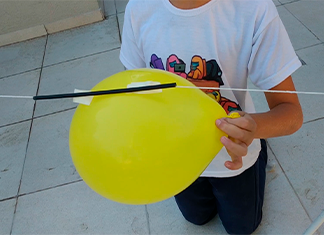 niño sosteniendo un globo cohete a punto de salir