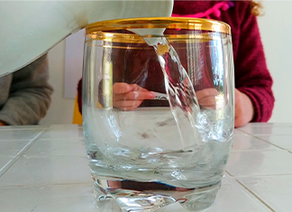 llenando un vaso con agua para eperimento de niños