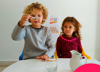 niño enseña un papel pequeño escrito de un experimento fácil