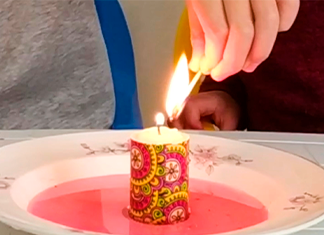 encendemos una vela que está en un plago con agua y colorante