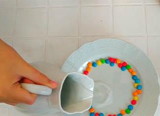 jarro vuelc agua en un plato con confites de colores