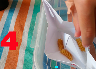 barco de papel con fideos tirabuzón adentro en una mesa de casa