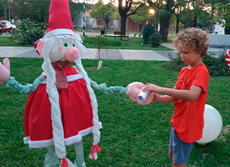 niño agarra mensaje escrito que tiene el duende de navidad