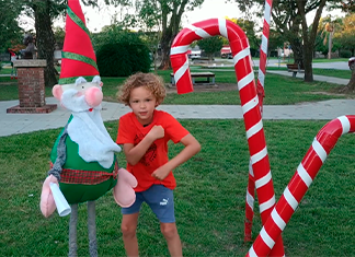 niño baila junto a un duende de navidad en la plaza