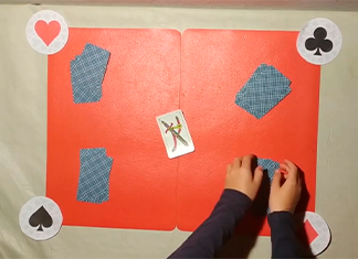 niño preparando mesa para magia con cartas