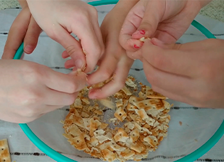 manos de niños moliendo masitas en un bowl