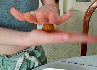 manos haciendo bolitas de galletitas y dulce de leche